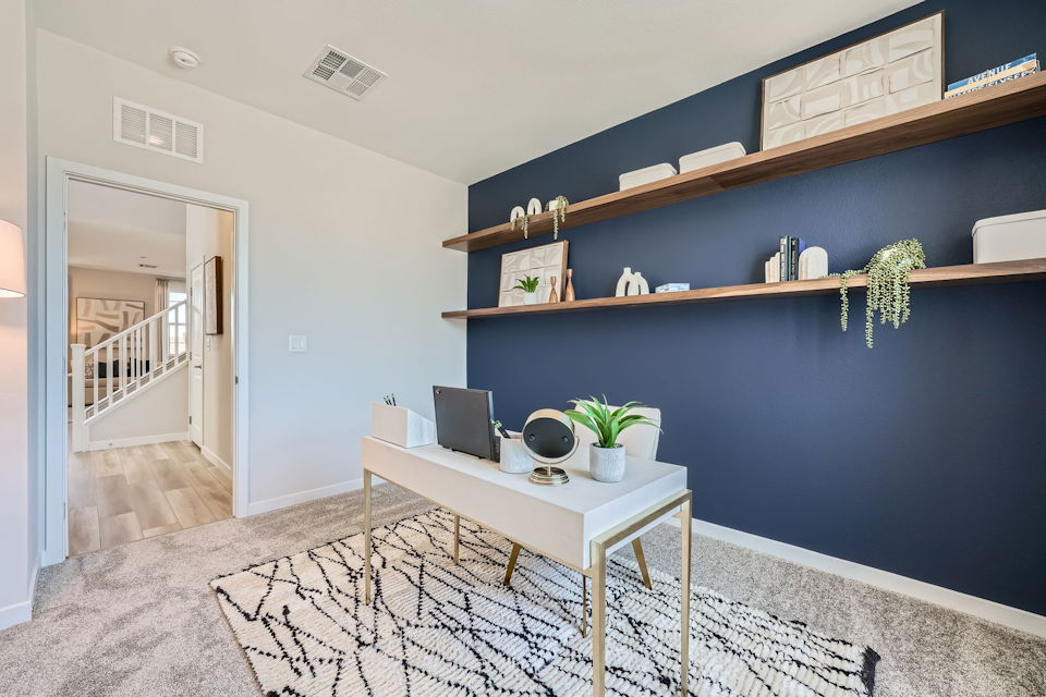 A room with a desk and shelves.