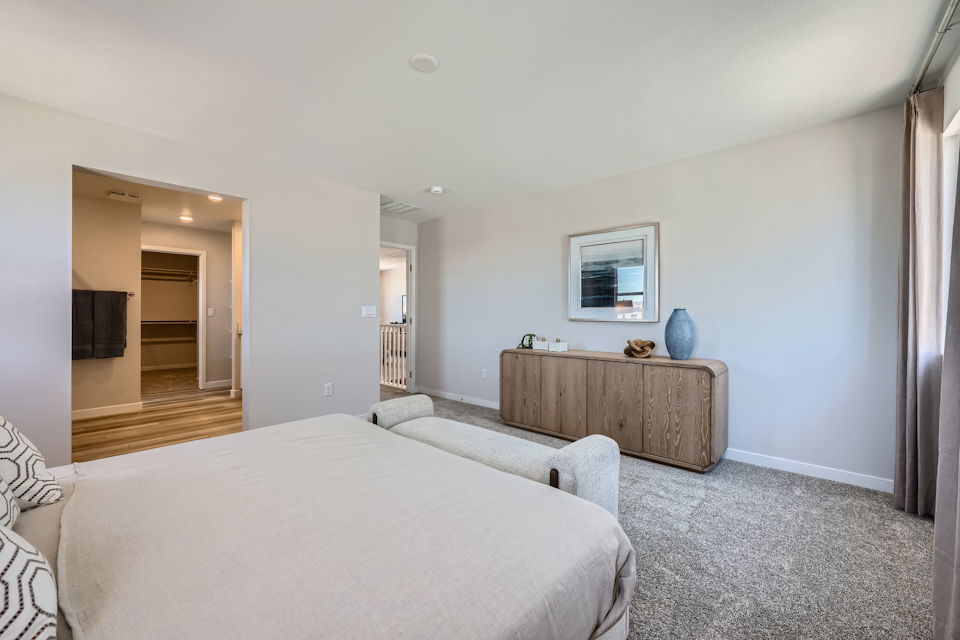 A bedroom with a bed and a table.