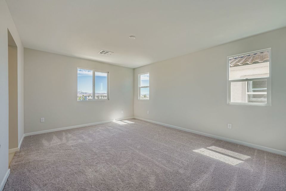 A room with a carpet and windows.