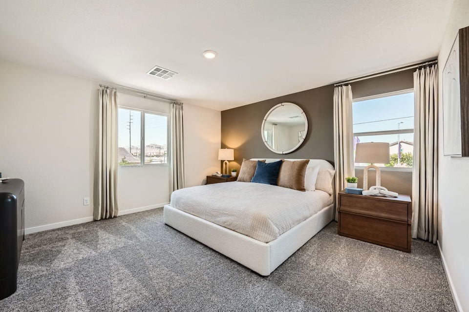A bedroom with a large mirror.