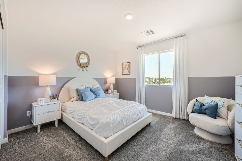 A bedroom with a bed and a chair.