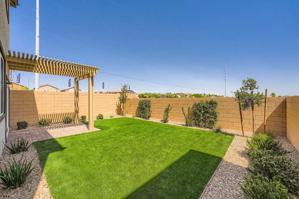 A backyard with a brick wall and a brick fence.