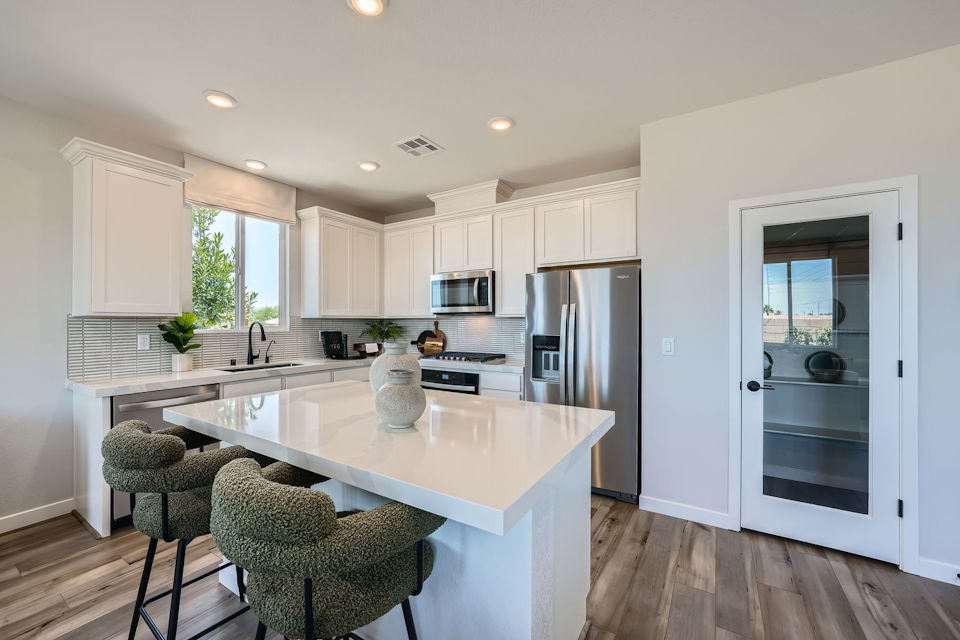 A kitchen with white cabinets.