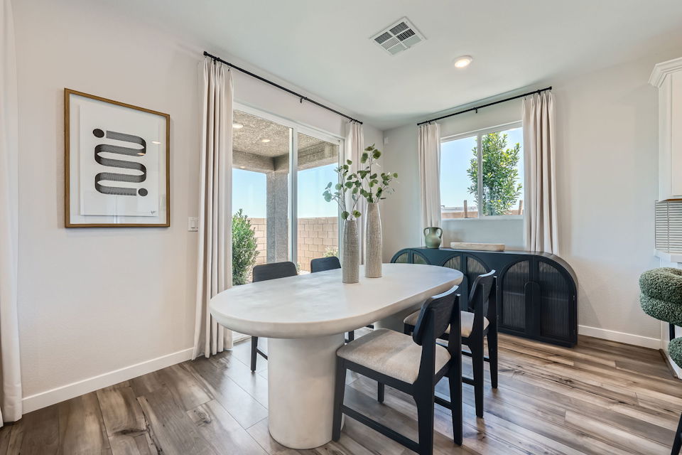 A dining room with a table and chairs.