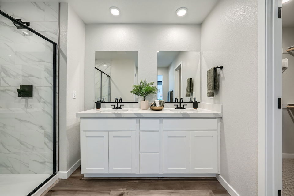 A bathroom with white cabinets.