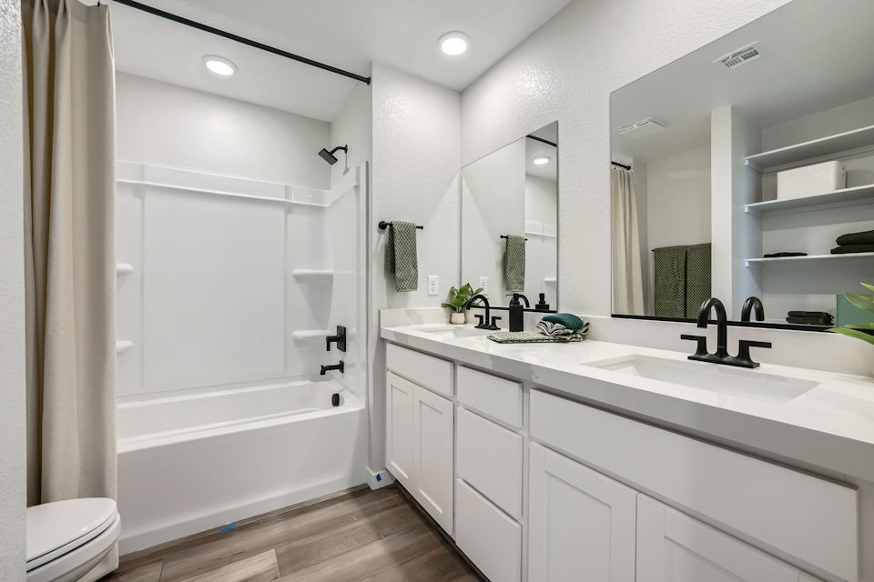 A bathroom with a tub sink and a toilet.