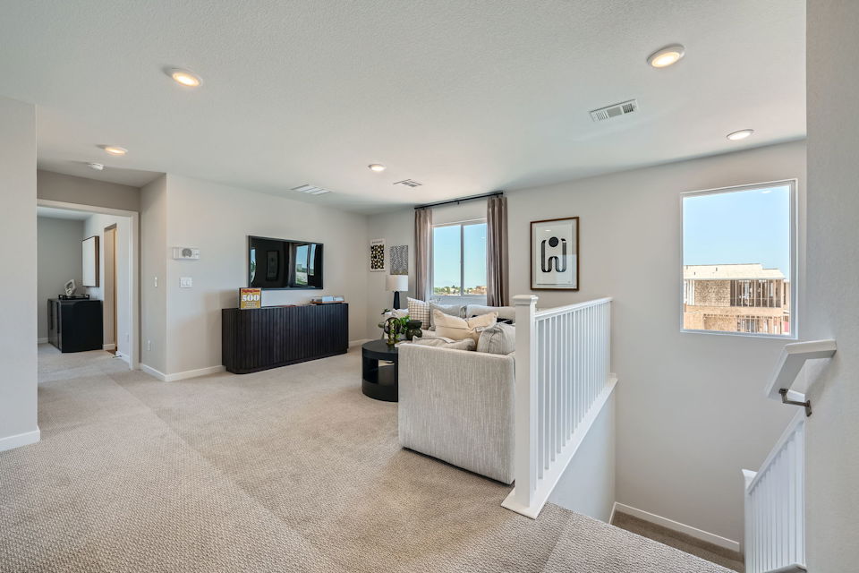 A large living room with a white bed and a black and white couch.