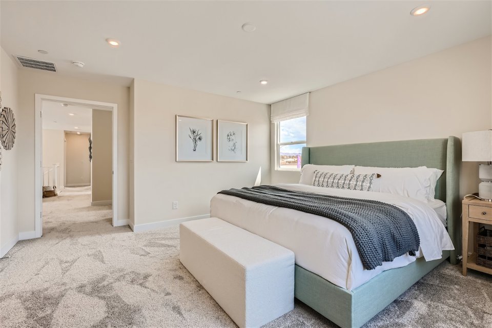 A bedroom with a bed and a bench.