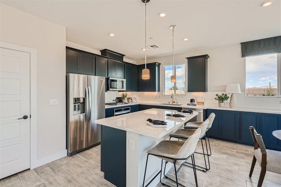 A kitchen with a bar and chairs.