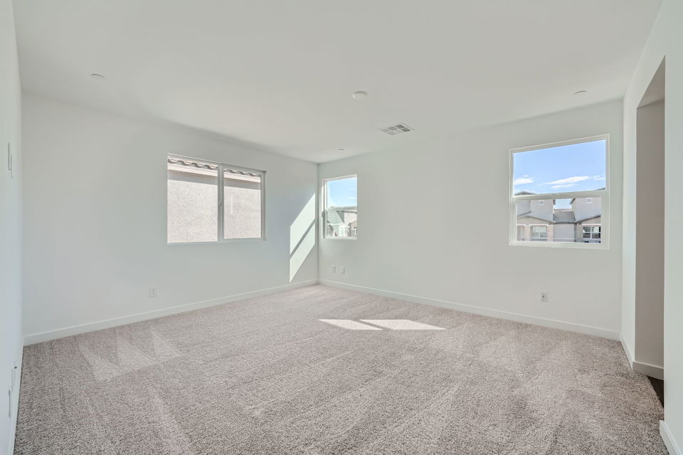 A room with a carpet and a window.