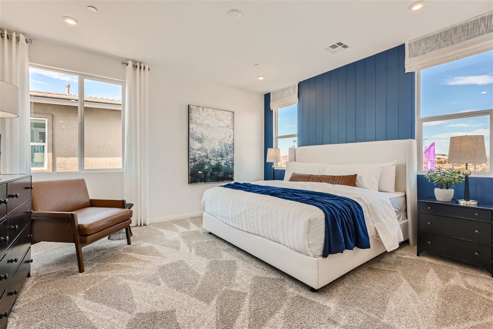 A bedroom with a bed and a chair.