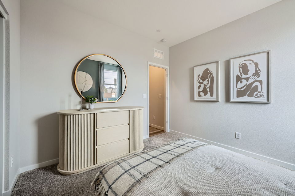 A room with a mirror and a dresser.