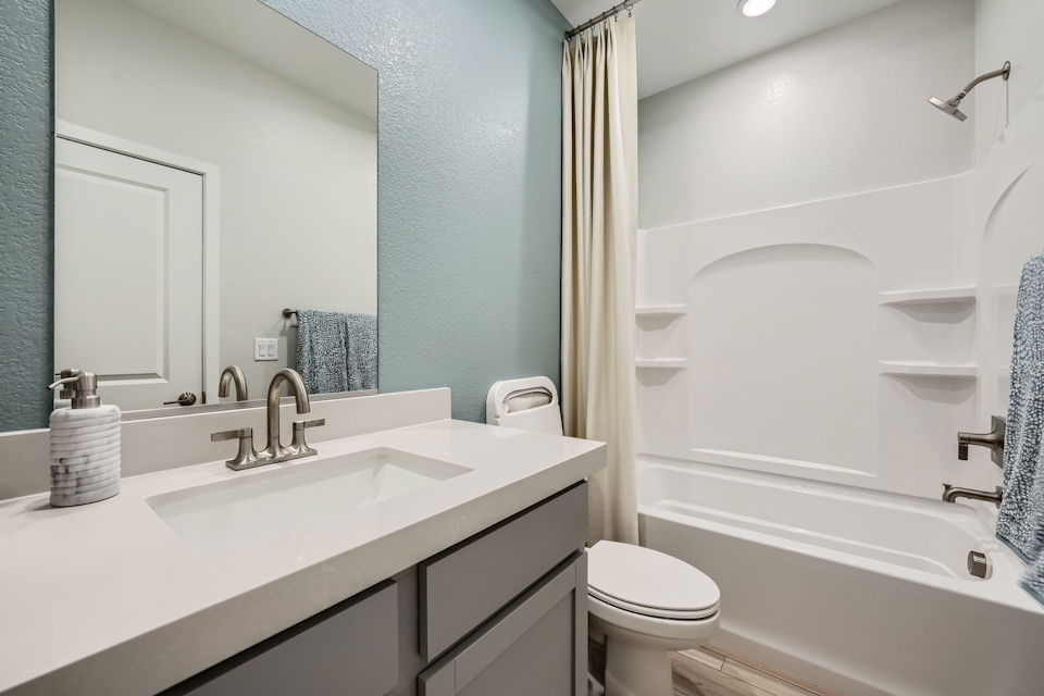 A bathroom with a tub sink and toilet.
