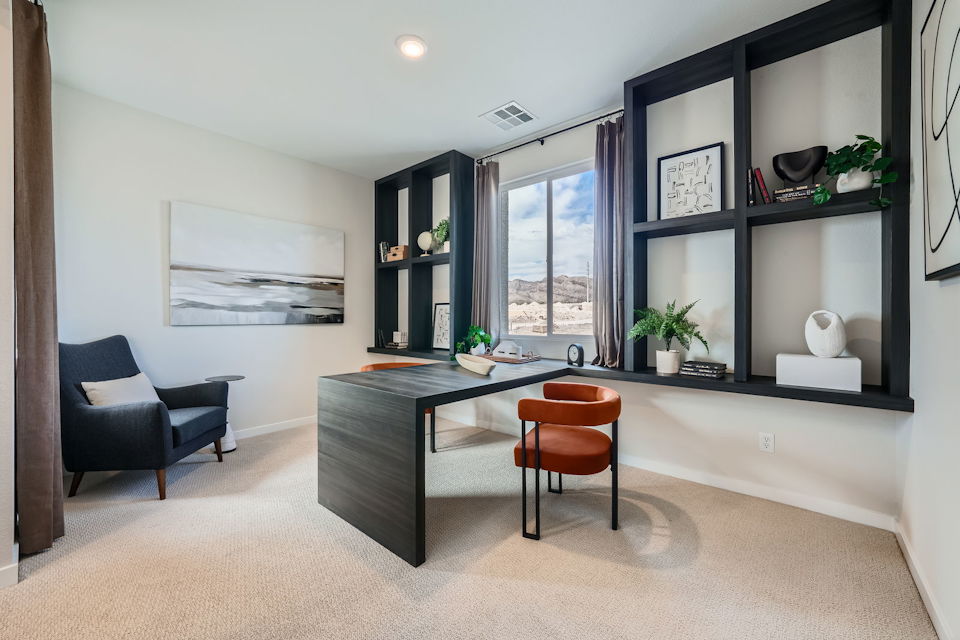 A room with a desk and chairs.