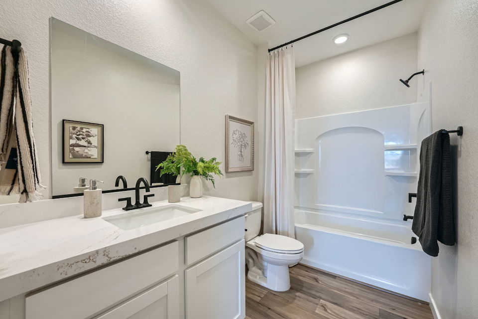 A bathroom with a tub sink and toilet.