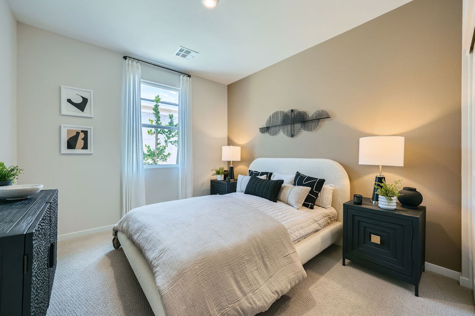 A bedroom with a bed and lamps.