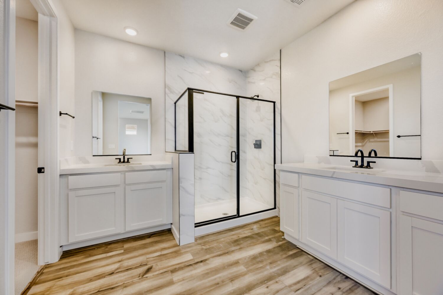A bathroom with white cabinets.