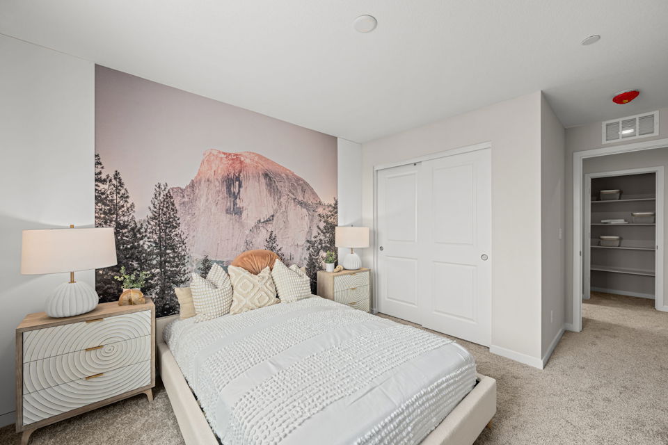 A bedroom with a large painting on the wall.
