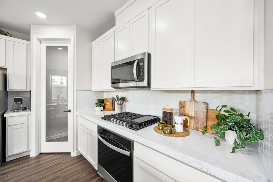 A kitchen with white cabinets.