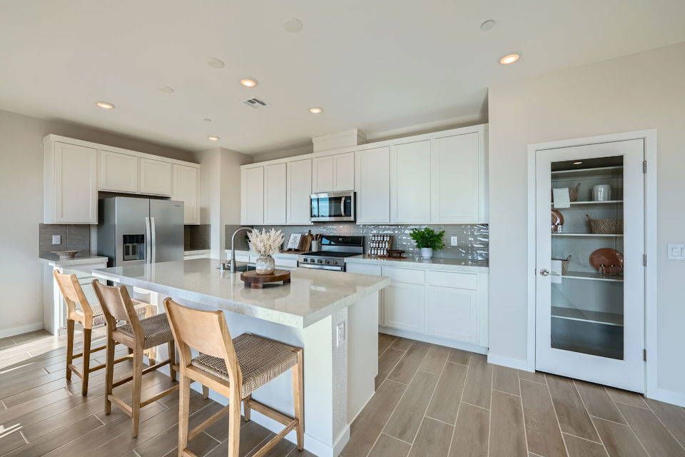 A kitchen with white cabinets.