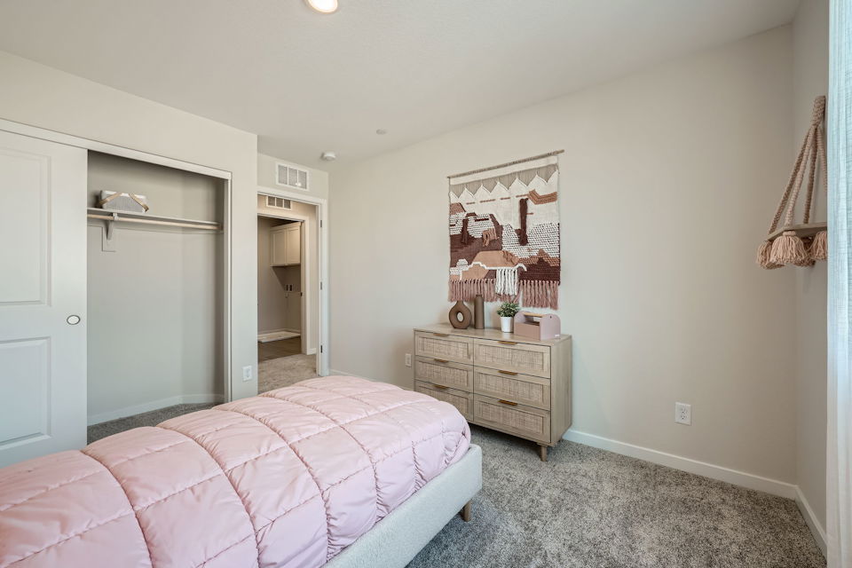 A bedroom with a pink bed.