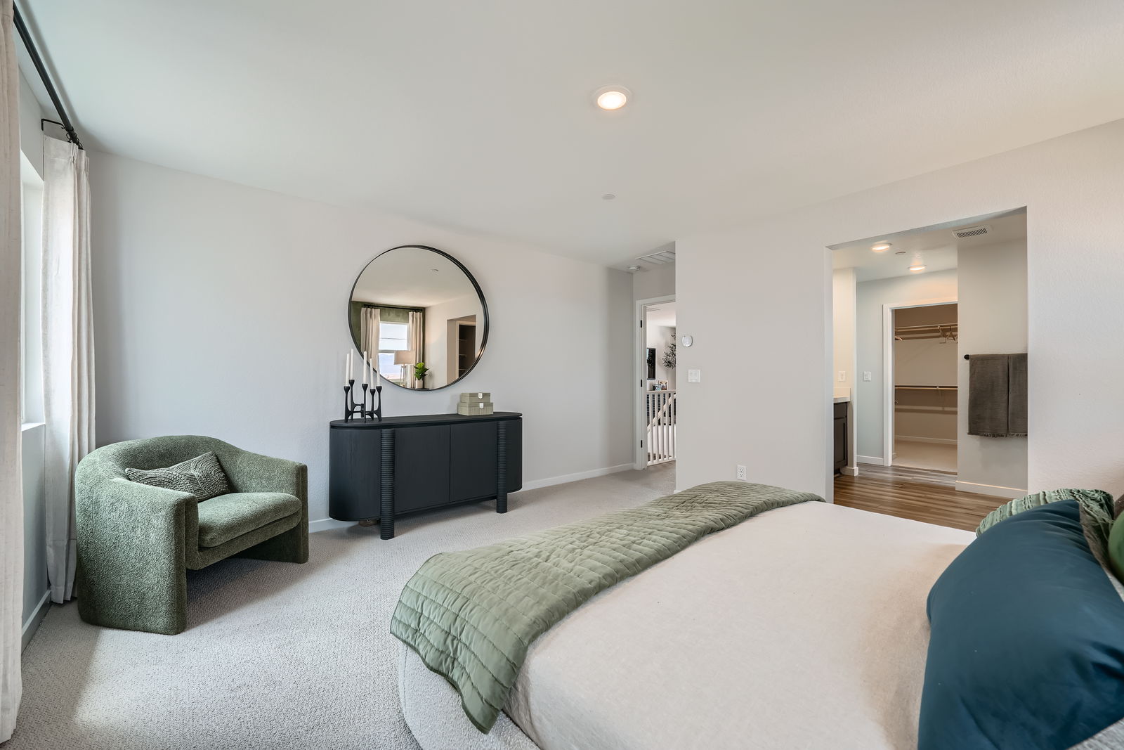 A bedroom with a bed and a chair.