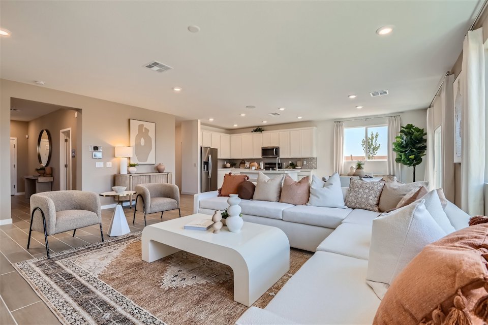 A large living room with a large white couch and a rug.