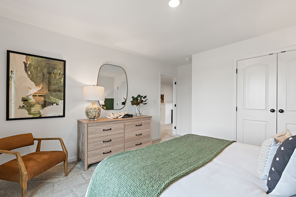 A bedroom with a bed and a mirror.