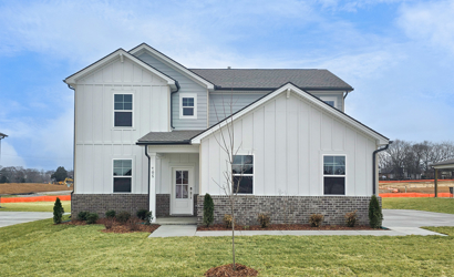 A white house with a stone wall.