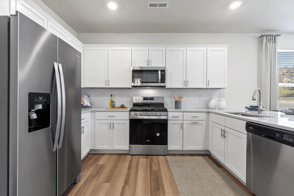 A kitchen with white cabinets.