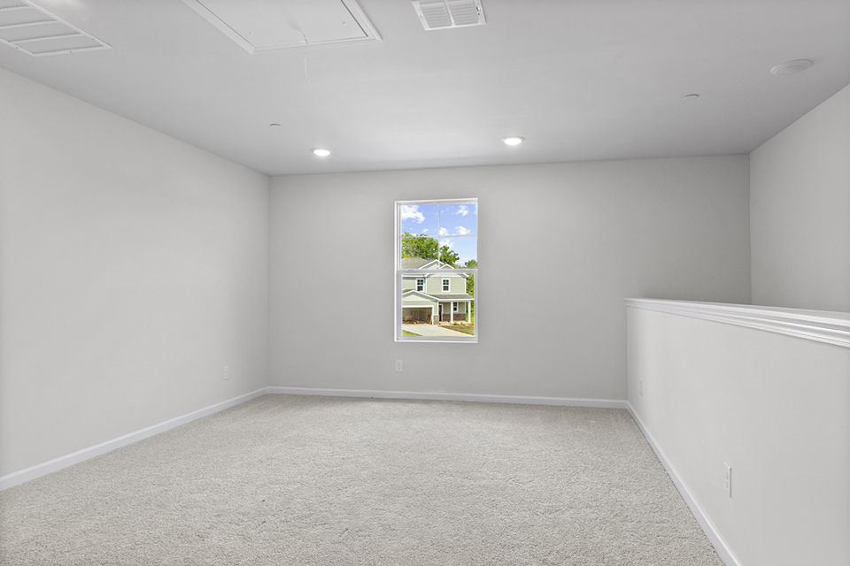 A room with a window and a white wall.