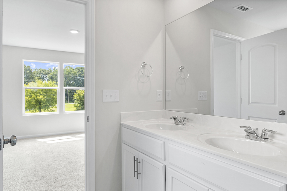 A bathroom with white cabinets.