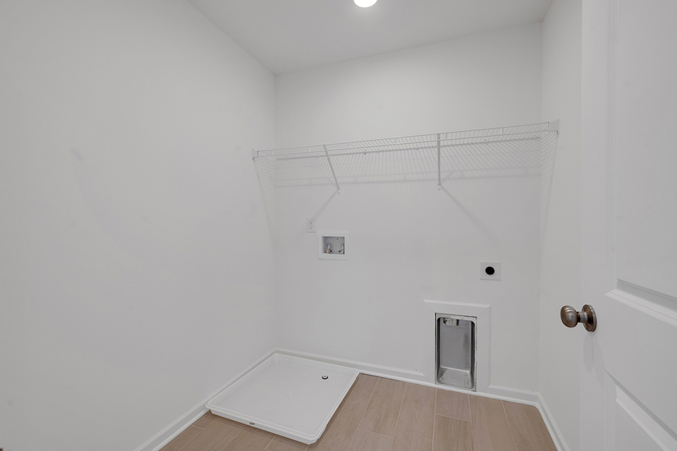 A white room with a wood floor and a white door.