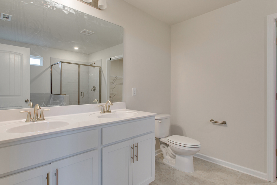 A bathroom with a toilet sink and mirror.