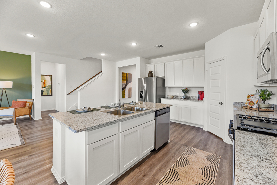 A kitchen with white cabinets.