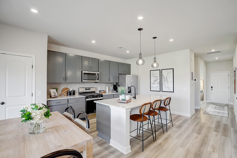 A kitchen with a dining table and white cabinets.