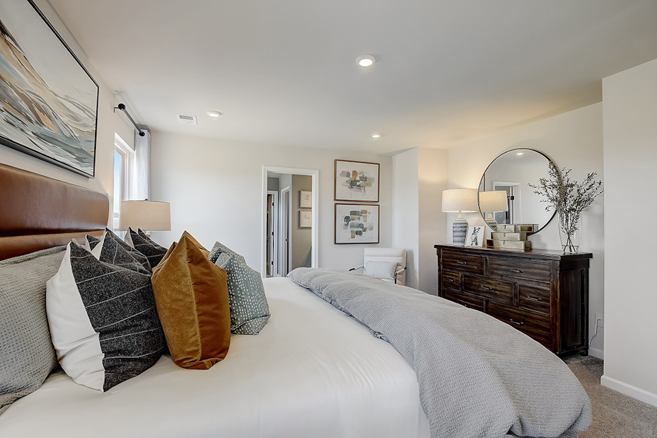 A bedroom with a bed and a mirror.