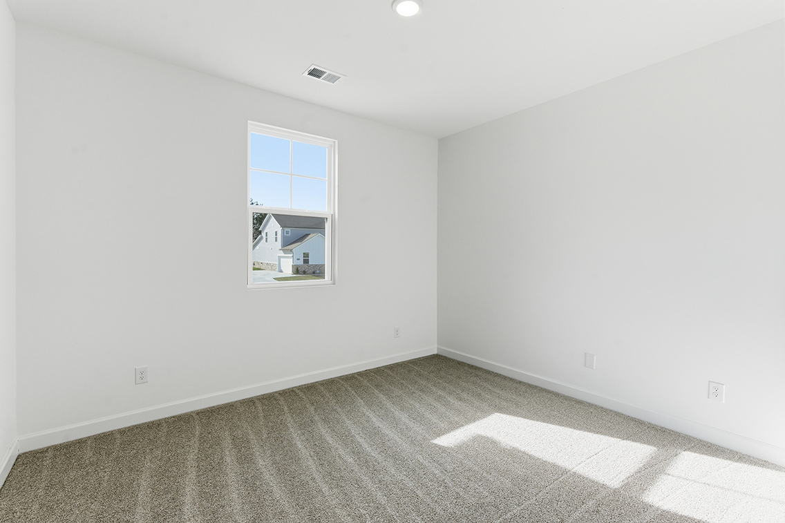 A room with a window and a painting on the wall.