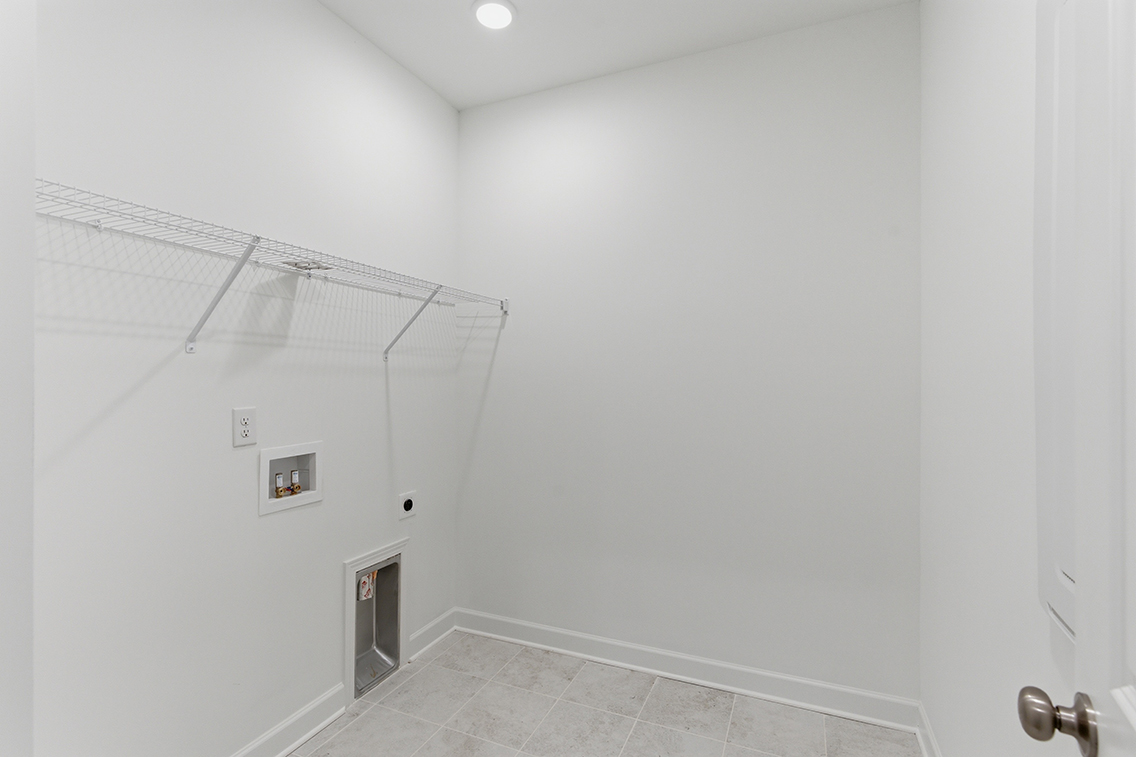 A white hallway with a light on the ceiling.