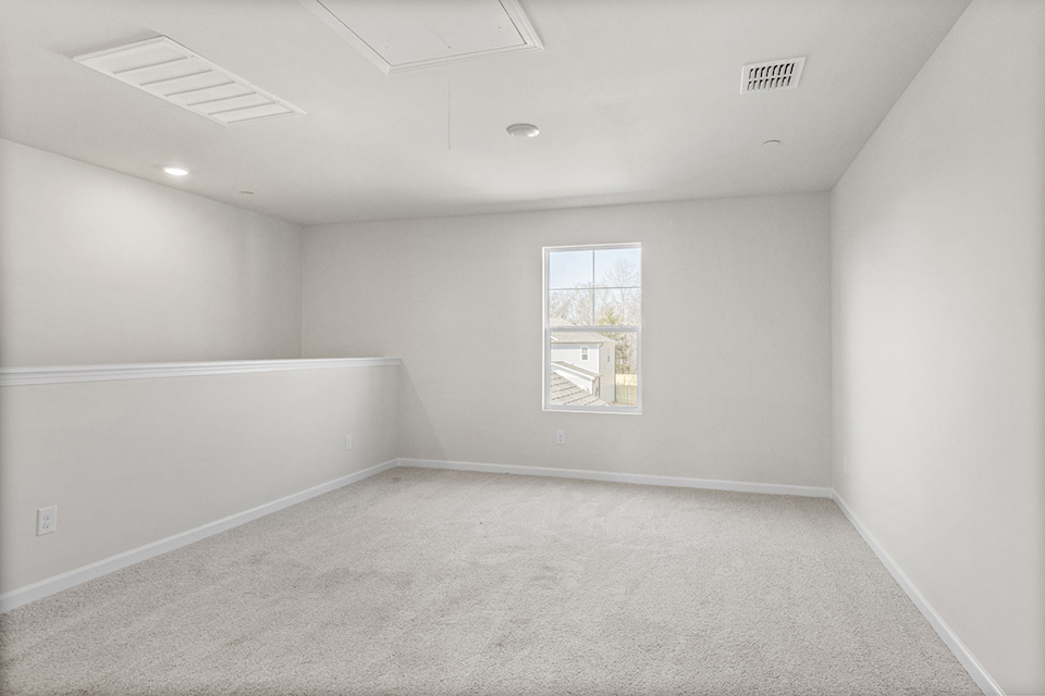 A room with a white wall and a painting on the wall.