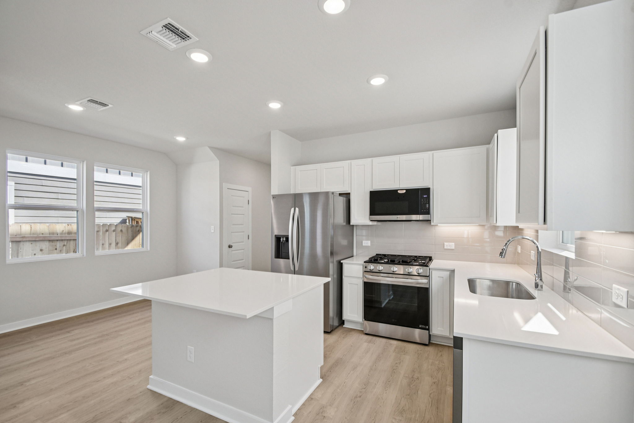 A kitchen with white cabinets.