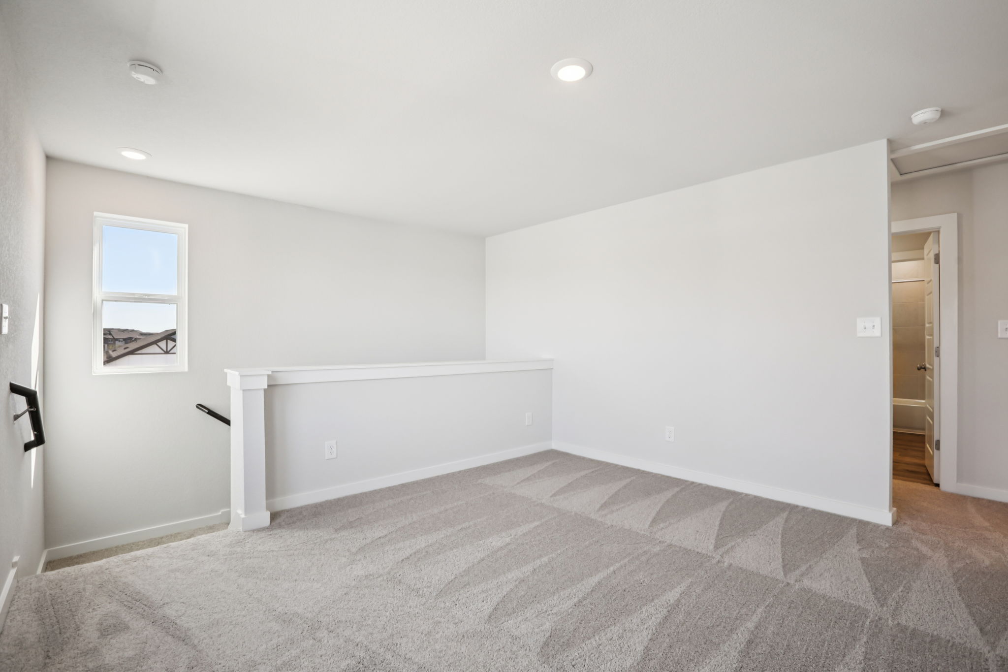 A room with a carpet and a white wall.