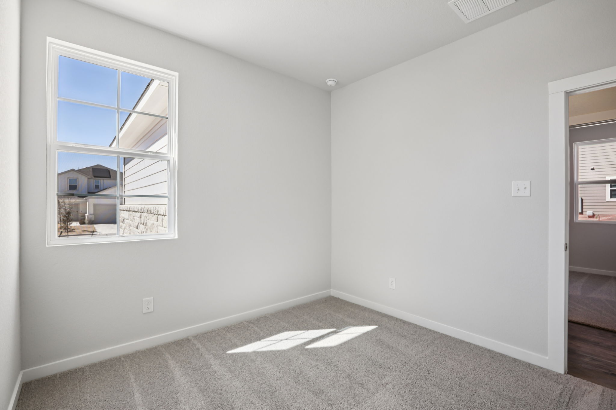 A room with a window and a carpet.