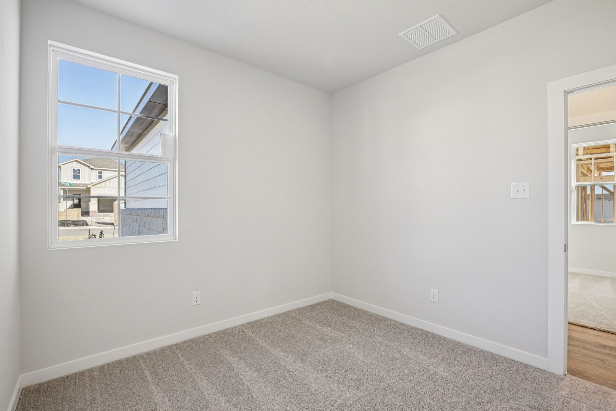 A room with a window and a carpet.