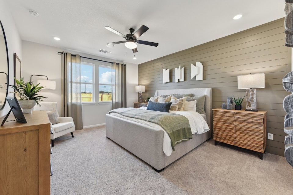 A bedroom with a bed and a fan.