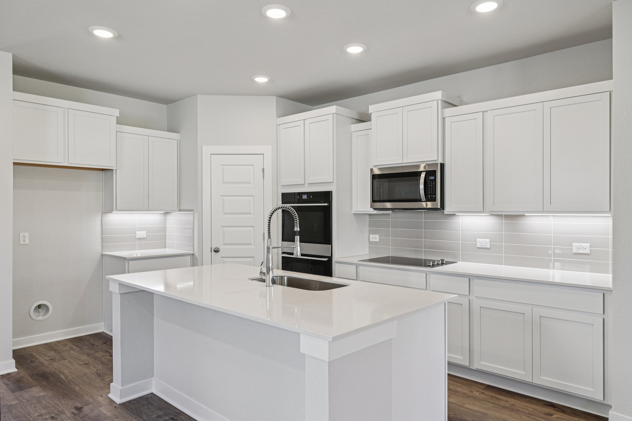 A kitchen with white cabinets.