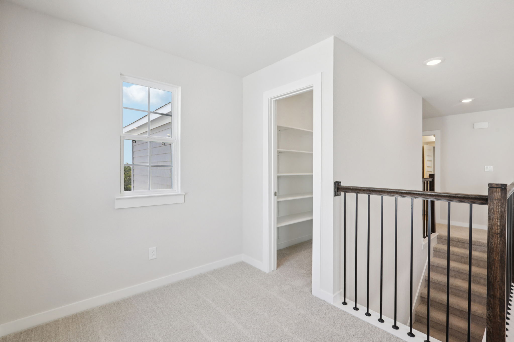 A white room with a black railing.