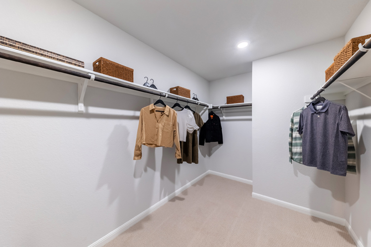 A room with a white wall and a white wall with a row of clothes on it.
