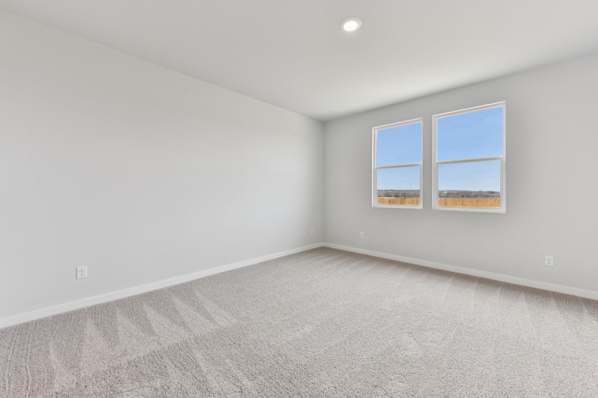 A room with a window and a carpet.