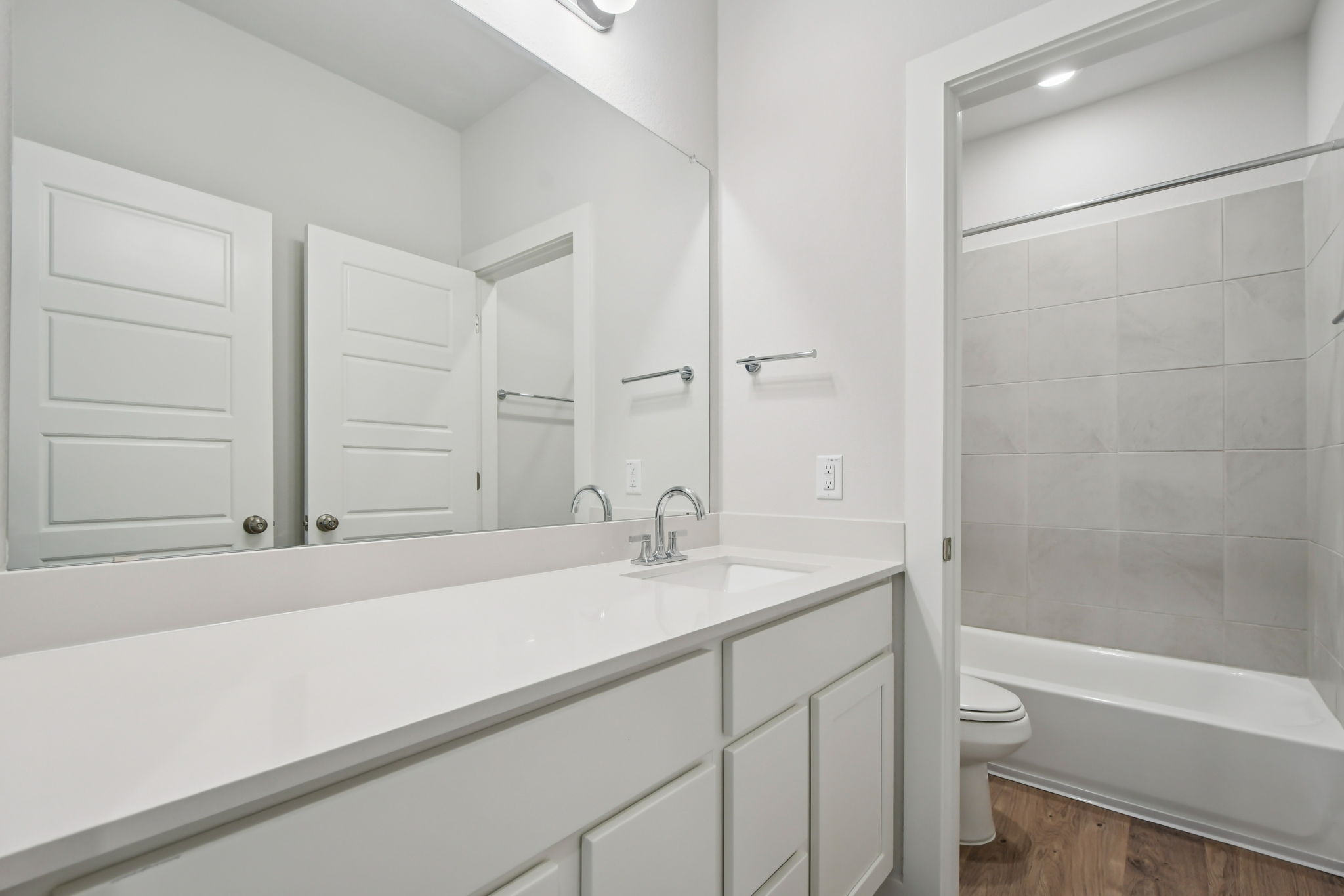 A bathroom with white cabinets.